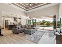 Open-concept living area boasts a coffered ceiling, wood flooring, and a seamless transition to the lanai at 9533 Arnaz Cir, Port Charlotte, FL 33981