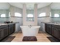 Luxurious bathroom with a freestanding tub, dual vanities, and arched windows for natural light at 9533 Arnaz Cir, Port Charlotte, FL 33981