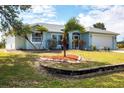 Charming single-story home with lush landscaping, lovely palm trees, and a well-maintained lawn at 10307 Grail Ave, Englewood, FL 34224