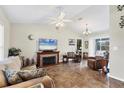 Inviting living room with a vaulted ceiling, a decorative fireplace, and sliding glass doors to the lanai at 10307 Grail Ave, Englewood, FL 34224