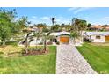 Charming single-story home with a paved driveway, a two-car garage, and mature landscaping at 232 Bahia Vista Dr, Englewood, FL 34223