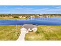 Beautiful lakefront home with manicured lawn, long driveway, and well-maintained exterior at 43 Blue Hen Dr, Placida, FL 33946