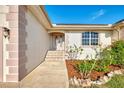 Charming entryway with colorful landscaping, decorative stone, and a tiled step path at 43 Blue Hen Dr, Placida, FL 33946