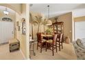 Dining area featuring a glass-top table, upholstered chairs, and a decorative mural, creating a welcoming atmosphere at 100 Hobo Rd, Rotonda West, FL 33947