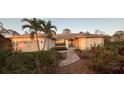 Charming single-story home featuring an attached garage, lush landscaping, and beautiful entryway at 1087 Bay Harbor Dr, Englewood, FL 34224