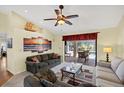 Comfortable living room with vaulted ceilings, ceiling fan, slider, and views of the lanai and pool at 1087 Bay Harbor Dr, Englewood, FL 34224