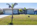 Charming single-story home with a well-manicured lawn and attached garage at 15610 Seafoam Cir, Port Charlotte, FL 33981
