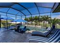 Inviting screened-in pool with water features, lounge chairs, and patio furniture at 15691 Meacham Cir, Port Charlotte, FL 33981