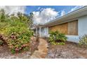 Charming single-story home with a stone walkway and beautiful flowering bushes at 295 North Dr, Englewood, FL 34223
