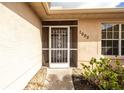 Inviting home entrance featuring a decorative screen door, well-kept landscaping, and clear numbering at 1003 Old Englewood Rd, Englewood, FL 34223