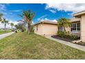 Beautiful home exterior with lush green lawn, palm trees, and a well-manicured landscape at 1003 Old Englewood Rd, Englewood, FL 34223