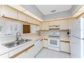 Bright kitchen featuring white appliances, ample counter space, and lots of upper cabinet storage at 11453 Oceanspray Blvd, Englewood, FL 34224