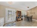 Dining area with a table set for four, stylish light fixture, and French doors to the back at 12028 Newgate Ave, Port Charlotte, FL 33981