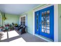 Cozy porch with blue door, seating and plants at 12028 Newgate Ave, Port Charlotte, FL 33981