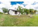 Landscaped yard of well-maintained single-story home featuring mature trees and lush green grass at 13360 Foresman Blvd, Port Charlotte, FL 33981