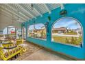 Spacious covered porch with comfortable seating and arched windows offering a view of the neighborhood at 13559 Martha Ave, Port Charlotte, FL 33981