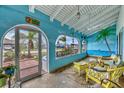 Inviting porch with ample seating, ceiling fan, a vibrant wall mural and scenic neighborhood views at 13559 Martha Ave, Port Charlotte, FL 33981