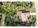 Aerial view of the home showcasing the large lot, mature trees and proximity to a quiet street at 14795 San Domingo Blvd, Port Charlotte, FL 33981