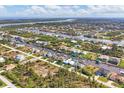An aerial view of a charming residential neighborhood featuring canal-front homes and lush greenery at 15776 Melport Cir, Port Charlotte, FL 33981