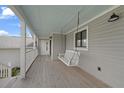 Cozy front porch with a swing, perfect for enjoying relaxing outdoor moments at 18 Pebble Beach Road, Rotonda West, FL 33947