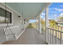 Welcoming front porch featuring a swing and offering a glimpse of the surrounding greenery at 18 Pebble Beach Road, Rotonda West, FL 33947