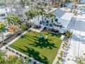 Charming backyard featuring a lush lawn, palm trees, and outdoor seating, perfect for relaxation and entertaining at 205 Sand Dollar Ln, Englewood, FL 34223