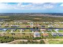 Panoramic aerial view of homes along a canal, set against a backdrop of lush greenery and water at 237 W Pine Valley Ln, Rotonda West, FL 33947