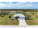 Expansive aerial view of a modern home surrounded by lush greenery and neighboring homes at 237 W Pine Valley Ln, Rotonda West, FL 33947