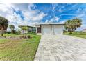 Beautiful single-story home with a spacious driveway and a well-manicured lawn with palm trees at 237 W Pine Valley Ln, Rotonda West, FL 33947