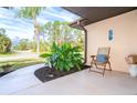 Cozy covered front porch with tropical plants and a chair at 2948 Briant St, North Port, FL 34287