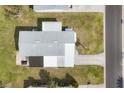 An aerial view showing a house with a grey roof, carport, and a well-maintained lawn at 8436 Buttonquail Dr, Englewood, FL 34224