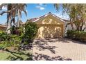 Inviting home showcasing a terracotta roof, well-manicured landscaping, and brick paved driveway at 10508 Crooked Creek Dr, Venice, FL 34293