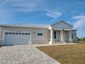 Charming single-story home with a metal roof, a two-car garage, and a well-manicured front yard at 10688 Mcalester Cir, Port Charlotte, FL 33981