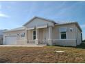 Inviting single-story home showcasing a well-maintained lawn, two-car garage, and a charming front porch at 10688 Mcalester Cir, Port Charlotte, FL 33981