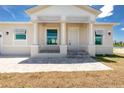 Welcoming covered front porch with decorative columns and stone paver walkway at 10688 Mcalester Cir, Port Charlotte, FL 33981