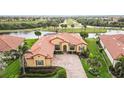 Stunning aerial view of the home with well-maintained lawn, mature palm trees, and beautiful golf course views at 10953 Bullrush Dr, Venice, FL 34293