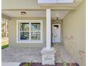 Inviting front porch with stone accents, stylish lighting, and a well-manicured landscape at 1183 Cedar Ave, Englewood, FL 34223