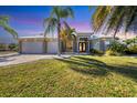 Beautiful single-Gathering home with a three-car garage, well manicured lawn, and elegant entryway at 14157 Kewanee Ln, Port Charlotte, FL 33981