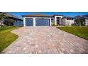 Long brick driveway leads to a modern home with well-maintained landscaping on a bright, sunny day at 14718 San Domingo Blvd, Port Charlotte, FL 33981