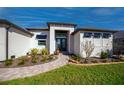 Welcoming front entry features a brick walkway, beautiful landscaping, and a modern double-door entrance at 14718 San Domingo Blvd, Port Charlotte, FL 33981