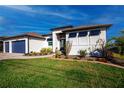 Charming home showcasing manicured landscaping, a well-maintained lawn, and an inviting facade at 14718 San Domingo Blvd, Port Charlotte, FL 33981