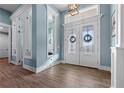 Bright foyer features wood-look tile floors and decorative glass double doors at 15044 Acorn Cir, Port Charlotte, FL 33981