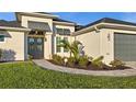 Inviting home entrance with elegant double doors, lush landscaping, and paver walkway at 15044 Acorn Cir, Port Charlotte, FL 33981