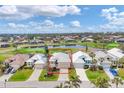 Aerial view of a well-maintained home near a golf course and a scenic lake, surrounded by lush greenery at 16 Windward Ter, Placida, FL 33946