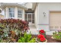 Inviting front entrance with screened porch, beautiful landscaping, and a well-lit pathway leading to the front door at 16 Windward Ter, Placida, FL 33946