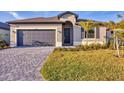 Charming single-story home with a gray garage door, walkway, and freshly cut green grass at 1602 Saddlewood Cir, Port Charlotte, FL 33953