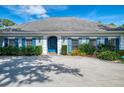 Charming house with gray roof, blue shutters, lush landscaping, and a spacious driveway for parking at 17 Dominica Dr, Englewood, FL 34223