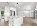 Bright kitchen with white cabinets, island, stainless steel appliances and sliding doors to the outside at 2160 Palm Tree Dr, Punta Gorda, FL 33950