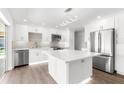 Modern kitchen with stainless steel appliances, an island, and white cabinets at 2160 Palm Tree Dr, Punta Gorda, FL 33950