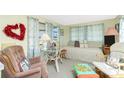 Inviting living room featuring a daybed and comfortable seating, complemented by bright curtains and accents at 3210 Holly Ave, Englewood, FL 34224